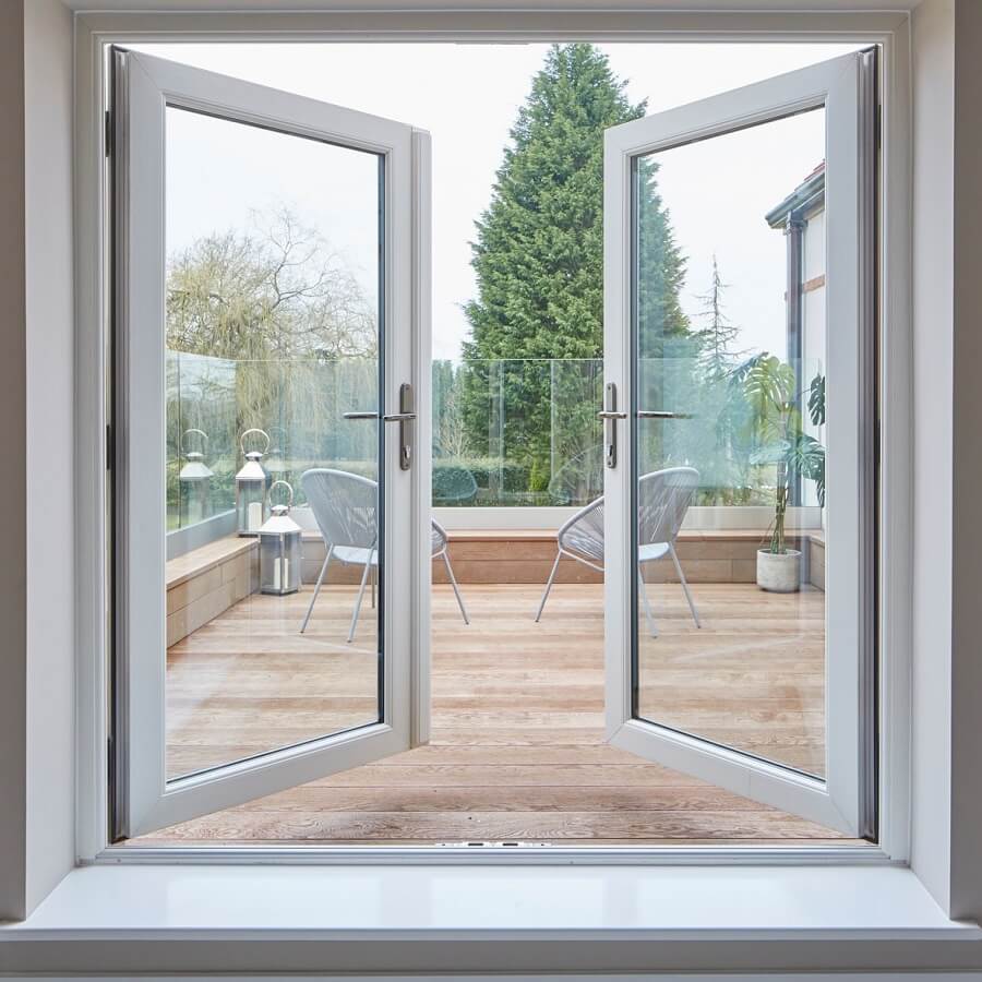 White Rustique French Doors looking out of a decked garden.