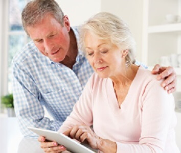 Elderly couple looking at something on a tablet